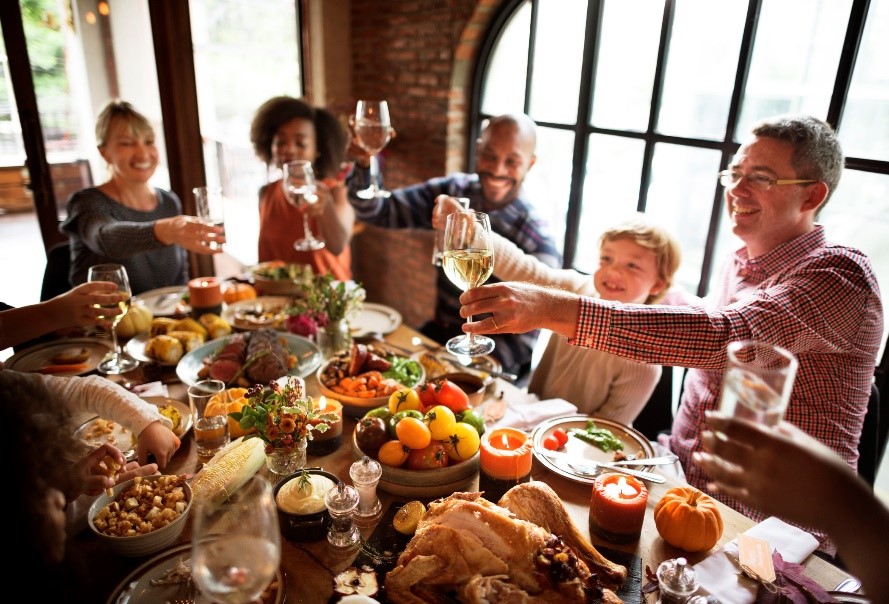 Group at holiday table - How to be a Good Thanksgiving Guest